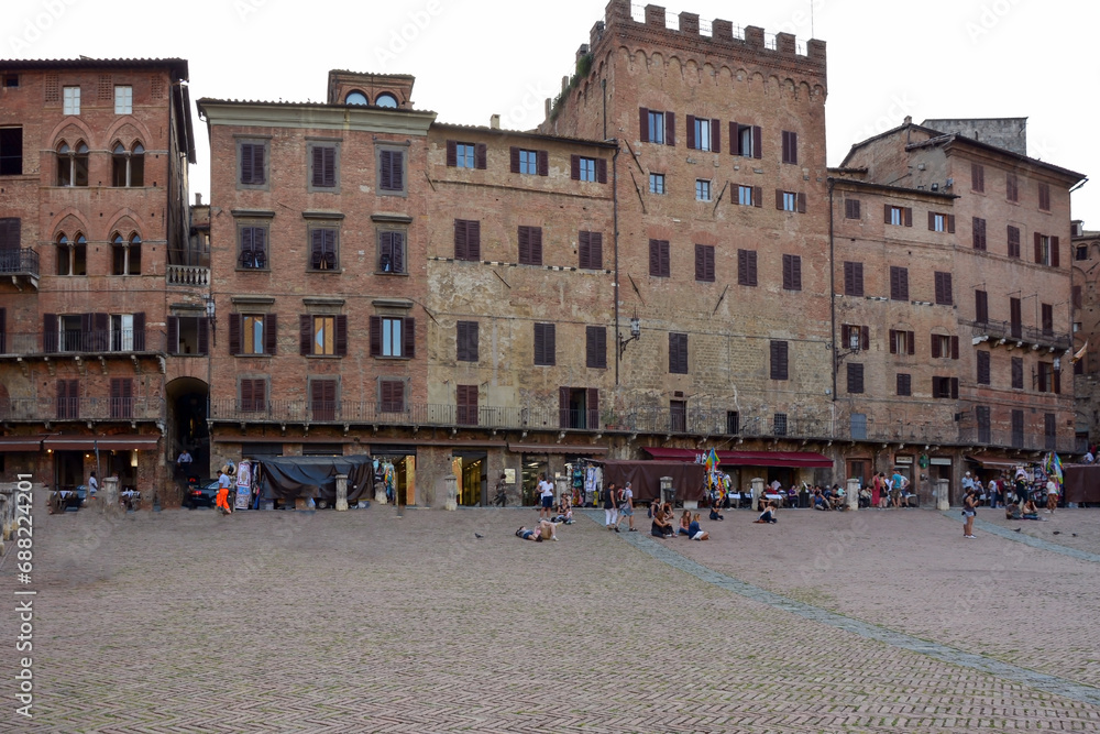 Old houses in a historic Italian city. Tourists and young people are walking near them