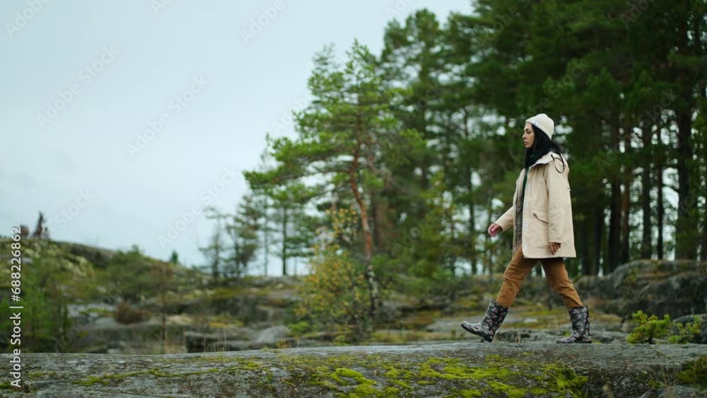 Female Traveler Walking Alone On Rock With Amazing Pine Forest In Background, Trip To Scandinavia Female Traveler Walking Alone On Rock With Amazing Pine Forest In Background, Trip To Scandinavia