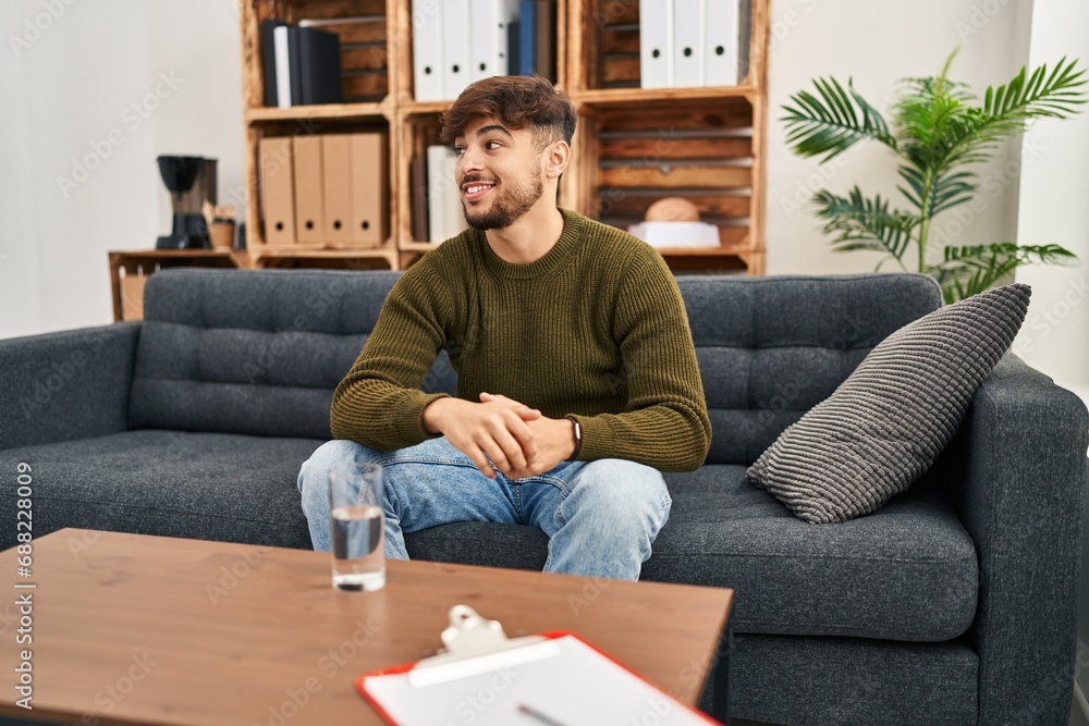 Arab man with beard working on depression at therapy office looking to side, relax profile pose with natural face and confident smile. Arab man with beard working on depression at therapy office looking to side, relax profile pose with natural face and confident smile.