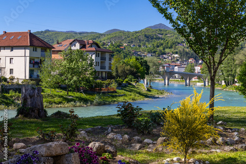 Park with river and a bridge in the background