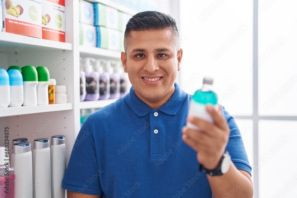 Young latin man customer smiling confident holding medication bottle at pharmacy Young latin man customer smiling confident holding medication bottle at pharmacy