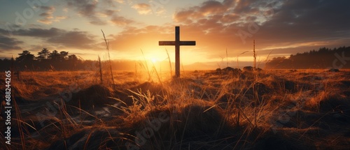 Silhouette Christian cross on grass in sunrise background photo