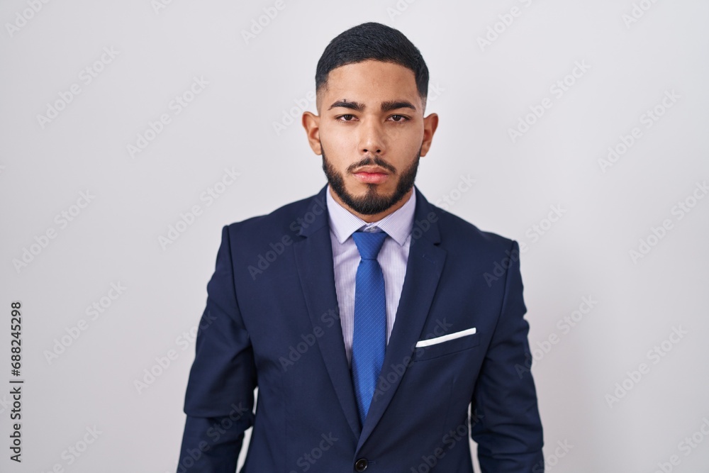 Young hispanic man wearing business suit and tie looking sleepy and tired, exhausted for fatigue and hangover, lazy eyes in the morning. Young hispanic man wearing business suit and tie looking sleepy and tired, exhausted for fatigue and hangover, lazy eyes in the morning.