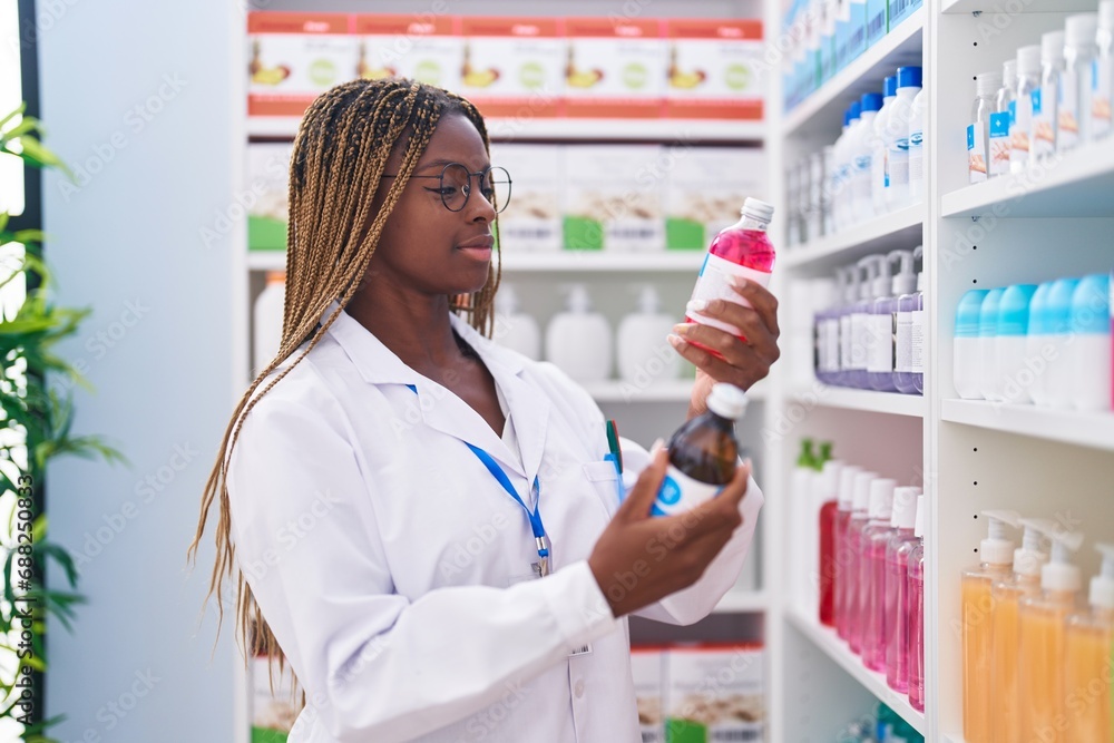 African american woman pharmacist holding medication bottles at pharmacy African american woman pharmacist holding medication bottles at pharmacy