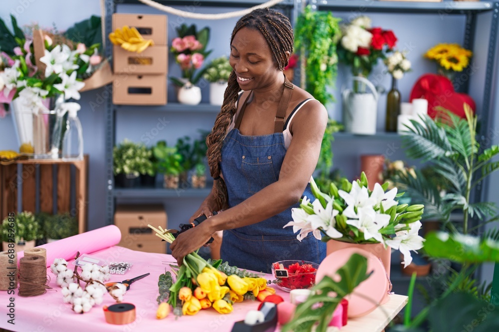 African american woman florist cutting stem at flower shop