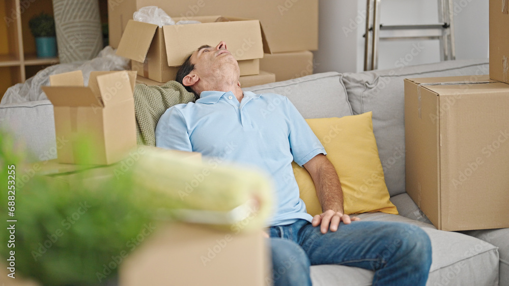 Middle age man relaxed on sofa at new home Middle age man relaxed on sofa at new home