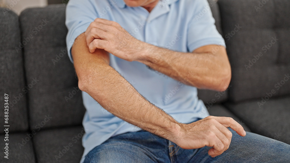 Middle age man scratching arm for itchy at home Middle age man scratching arm for itchy at home