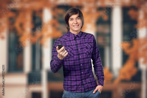 young man hold modern phone with expression of surprise