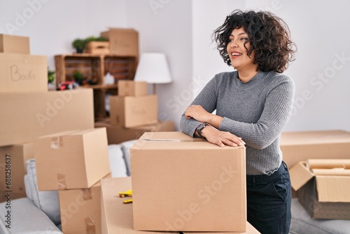 Young beautiful hispanic woman smiling confident leaning on package at new home © Krakenimages.com