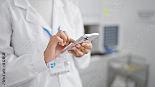 In the heart of science  hispanic woman scientist s hands busy texting on smartphone amidst lab work