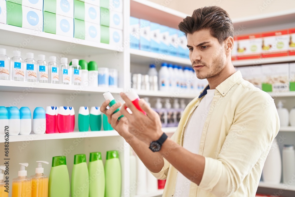 Young hispanic man customer holding toothpaste bottles at pharmacy Young hispanic man customer holding toothpaste bottles at pharmacy