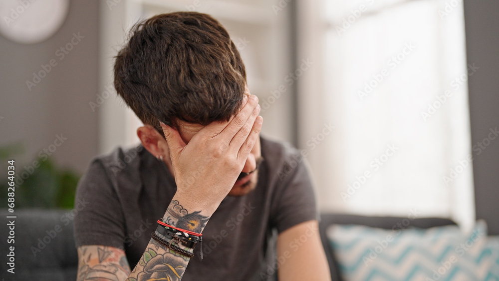 Young hispanic man stressed sitting on sofa at home Young hispanic man stressed sitting on sofa at home