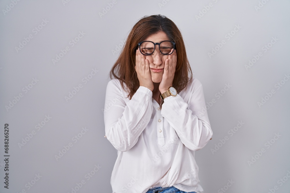 Brunette woman standing over white isolated background rubbing eyes for fatigue and headache, sleepy and tired expression. vision problem Brunette woman standing over white isolated background rubbing eyes for fatigue and headache, sleepy and tired expression. vision problem
