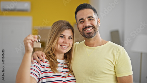 Man and woman couple hugging each other holding new house keys at new home © Krakenimages.com