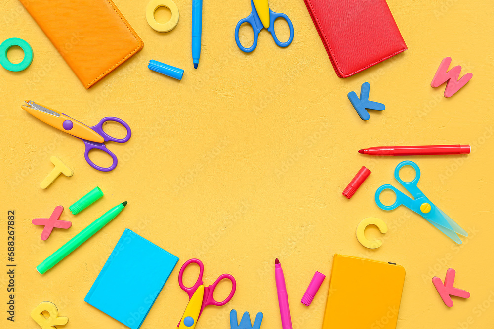 Frame made of colorful stationery on yellow background Frame made of colorful stationery on yellow background