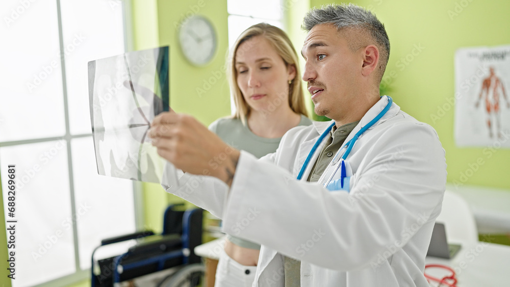Fototapeta premium Man and woman doctor and patient having medical consultation looking xray at the clinic
