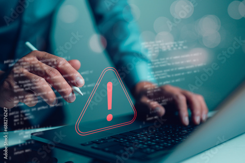 Canvas Print Businessman or it staffs, programmer, developer using computer laptop with triangle caution warning sign for notification error and maintenance concept