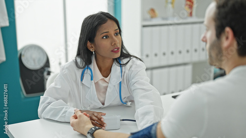 Doctor and patient sitting on table measuring pulse using tensiometer at the clinic