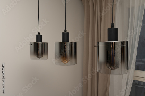 Three modern lamps. Three hanging lamps in the form of a cylinder with tinted glass.