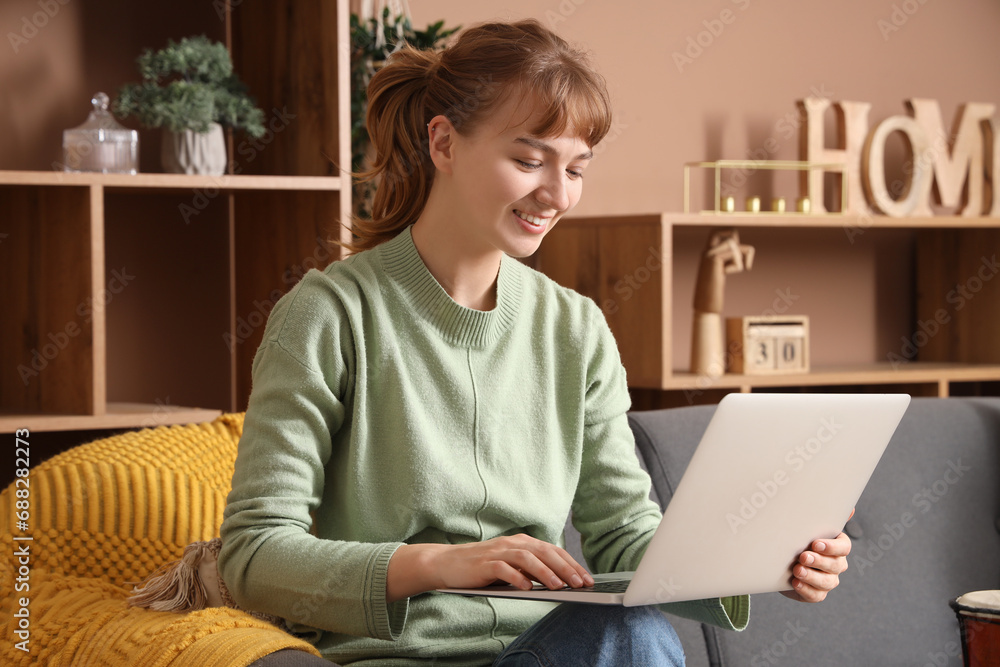 Young woman using laptop on sofa at home Young woman using laptop on sofa at home