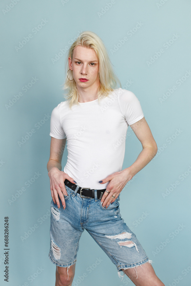 Studio photo of a fashionable man with make up isolated on blue background Studio photo of a fashionable man with make up isolated on blue background