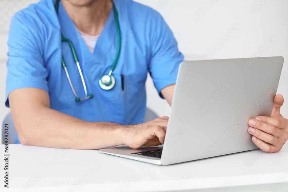 Mature doctor working with laptop at desk in medical office, closeup Mature doctor working with laptop at desk in medical office, closeup