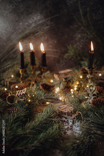 Christmas dark academia vintage winter wooden table with fir branches  pine cones  black candles and twinkle lights covered in fake snow
