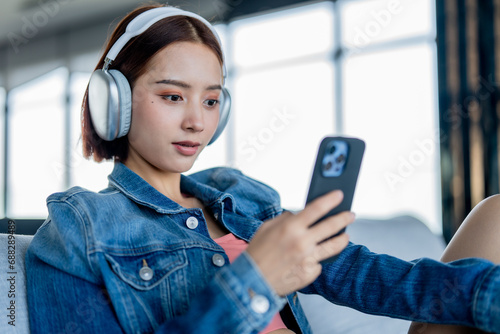 A young woman spends her vacation relaxing by listening to music and surfing the internet.