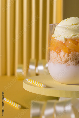 Glass with ice cream, chopped fruit, cake and Greek yogurt with happy birthday decoration.