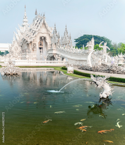Wat Rong Khun,the White Temple at dawn,and fish in the surrounding pond,outskirts of Chiang Rai,Northern Thailand.