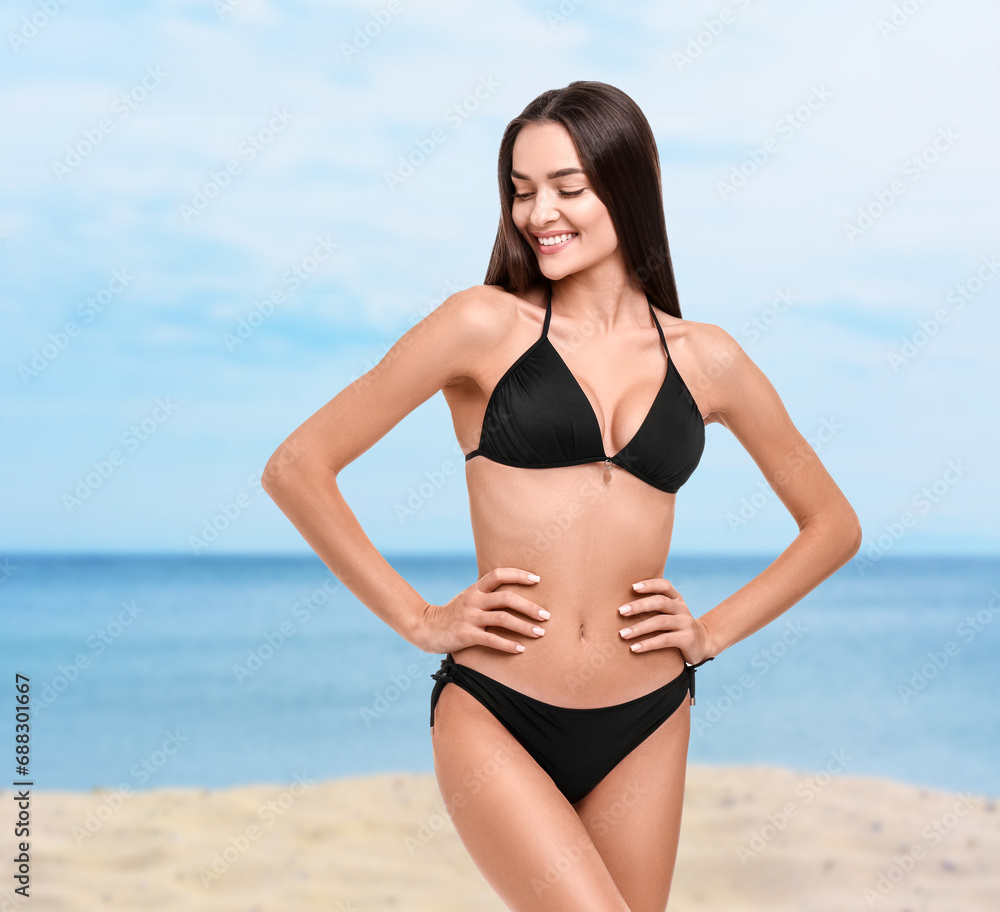 Happy woman in stylish black bikini on sandy beach near sea Happy woman in stylish black bikini on sandy beach near sea