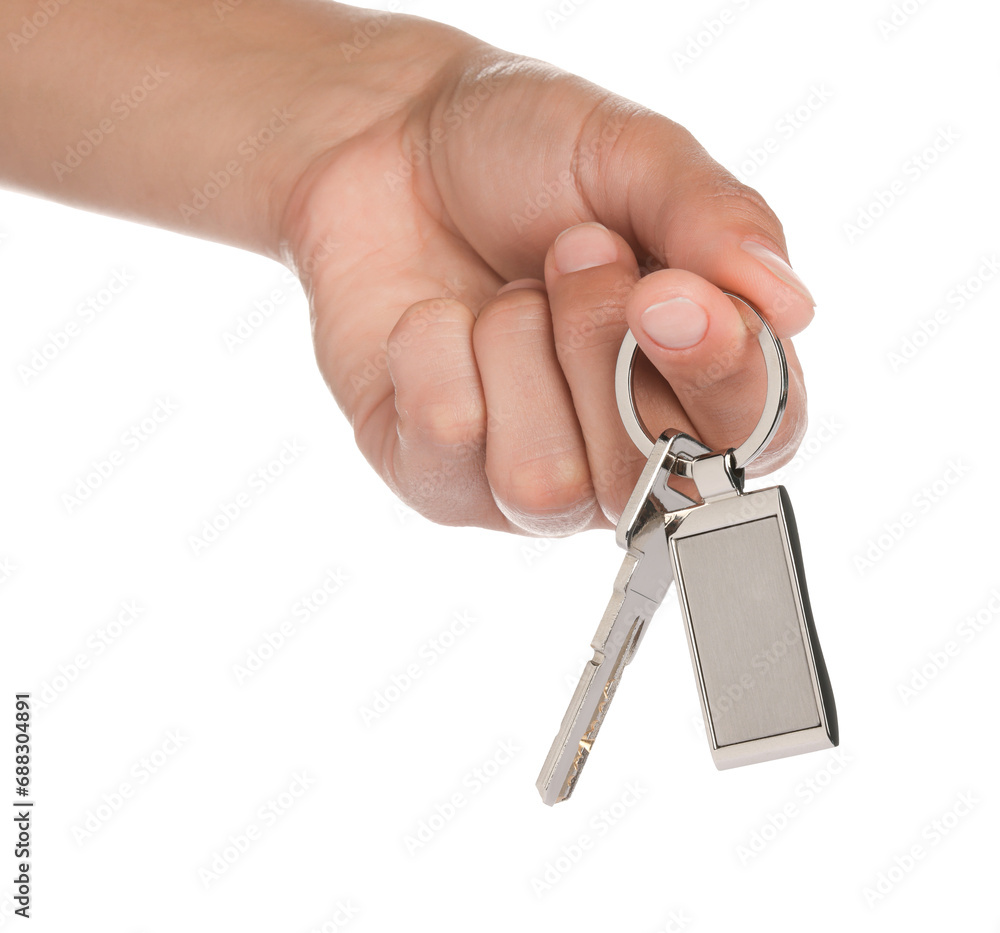 Woman holding key with metallic keychain on white background, closeup