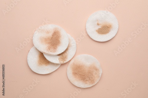 Dirty cotton pads after removing makeup on beige background, flat lay