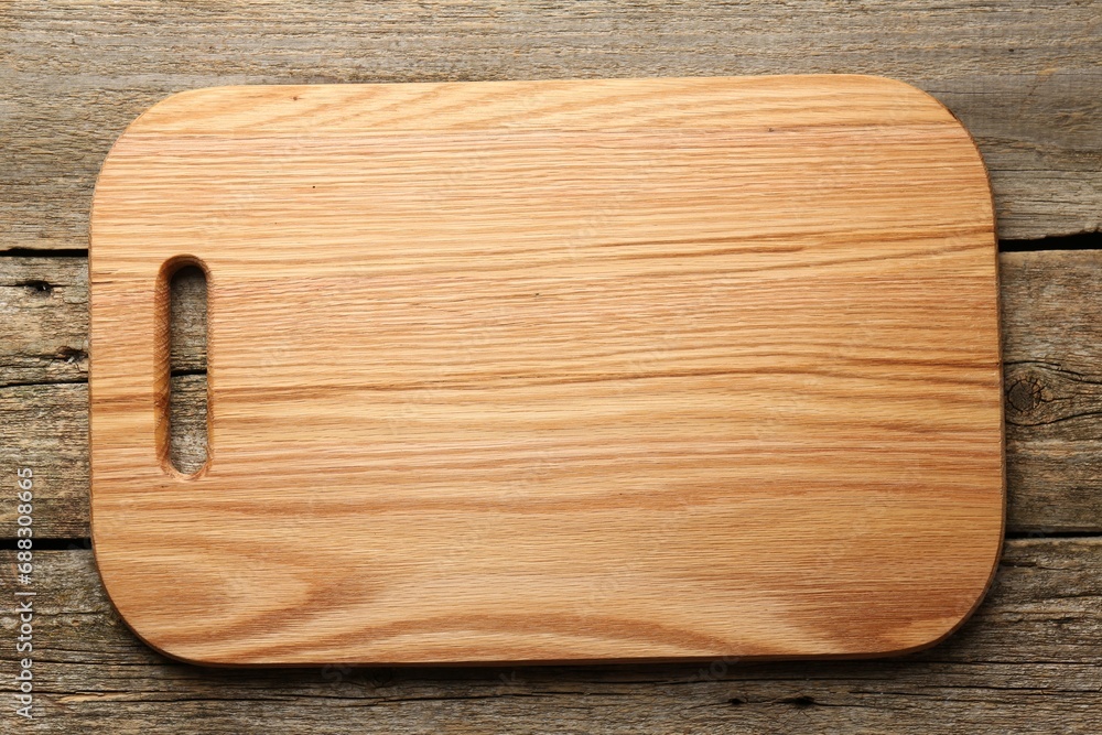 One new cutting board on old wooden table, top view One new cutting board on old wooden table, top view