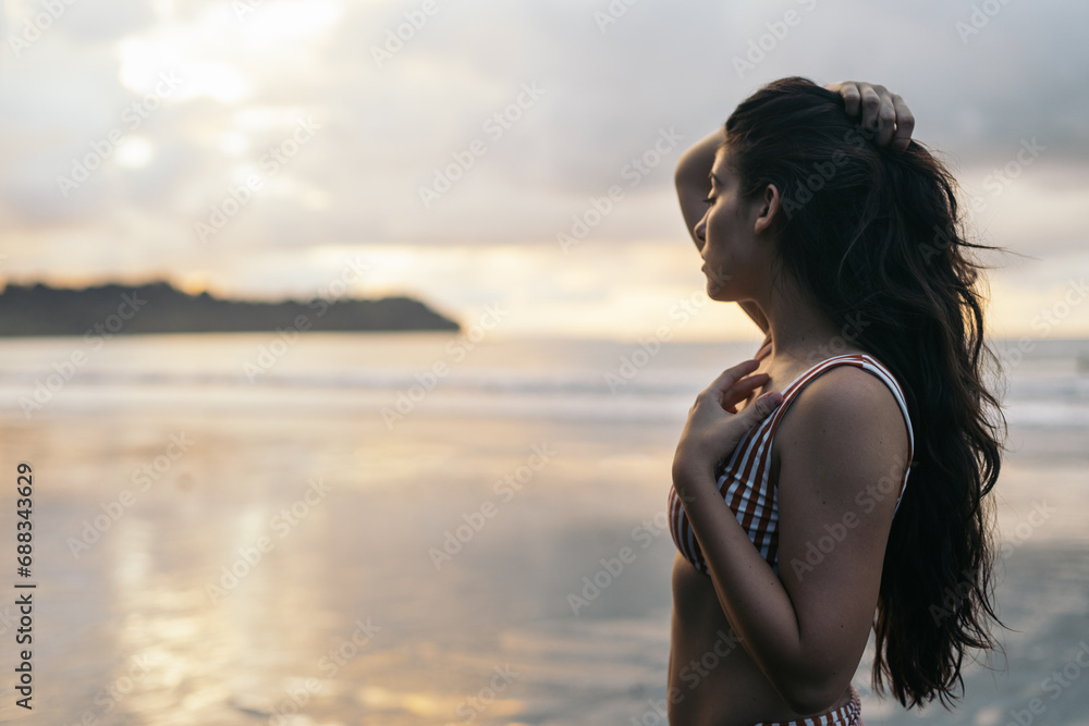 Young beautiful woman watching sunset on the beach Young beautiful woman watching sunset on the beach