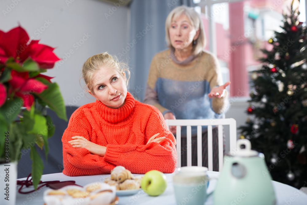 Mature woman scolds her adult daughter, who came to visit her before Christmas, pointing out her shortcomings