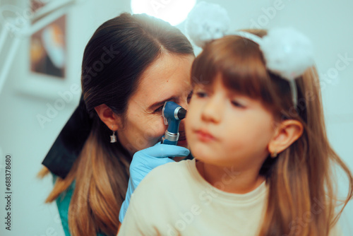 Doctor Holding Otoscope a Doing a Pediatric Ear Examination. Little kid having problem with otitis after a flu episode  
 photo