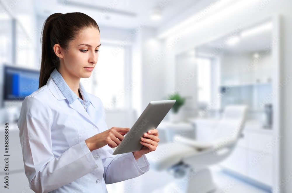 Young female dentist using a modern digital tablet Young female dentist using a modern digital tablet