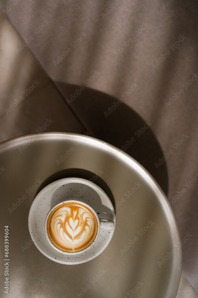 Cup of coffee latte on table and beautiful latte art with afternoon light in the cafe. Cup of coffee latte on table and beautiful latte art with afternoon light in the cafe.