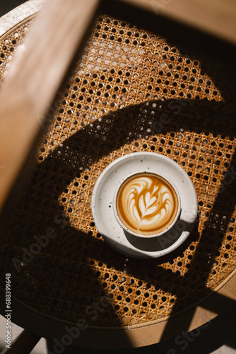 Cup of coffee latte on table and beautiful latte art with afternoon light. © Korradol