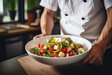 Close-up of a chef with Greek salad in the bowl