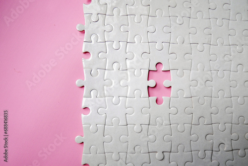 White jigsaw puzzle pattern missing pieces on pink background. Concept for expressing problem success solution alliance union teamwork