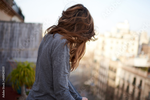 portrait of an anonymous young brunette woman with her hair covering her face and with Barcelona in the background photo