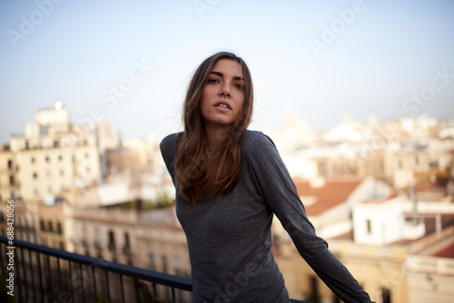portrait of a young white and brunette woman looking at camera with Barcelona in the background photo