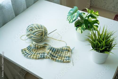 Knitting with green yarn on a white table photo