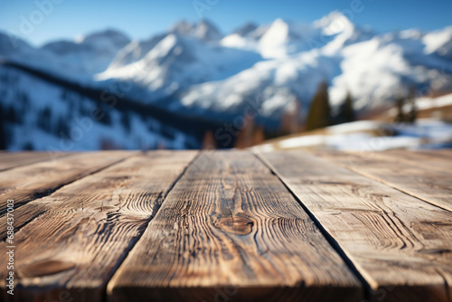 A wooden table boards and blurred defocused snow covered mountains view in the background.