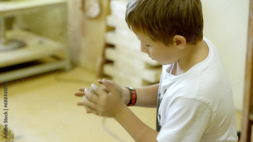 A boy works with clay in the ceramics studio A boy works with clay in the ceramics studio