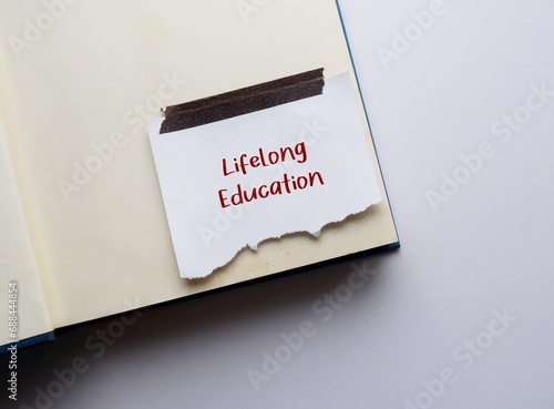 Book with stick note written Lifelong Education, means education resulting from integration of formal, non-formal, informal education for continuous lifelong development of quality of life