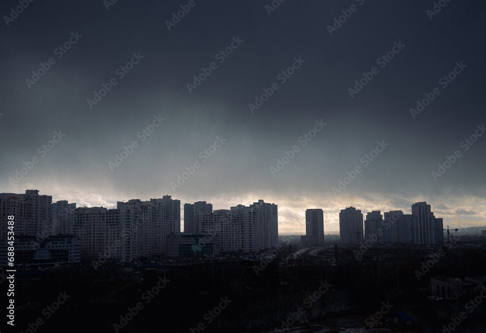 Fototapeta premium Dramatic snowstorm heavy clouds over city district.