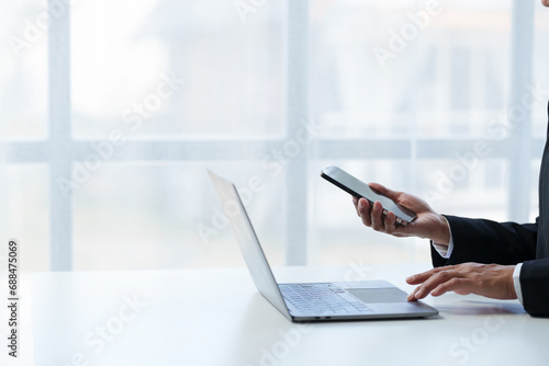 Businesswoman, investor analyzing stock market investment with financial panel, business intelligence on smartphone and laptop computer screen. Focus image. Concept. Technology. Communication.